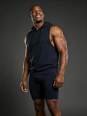 Black male bodybuilder 3/4 body portrait on seamless backdrop, dramatic studio lighting