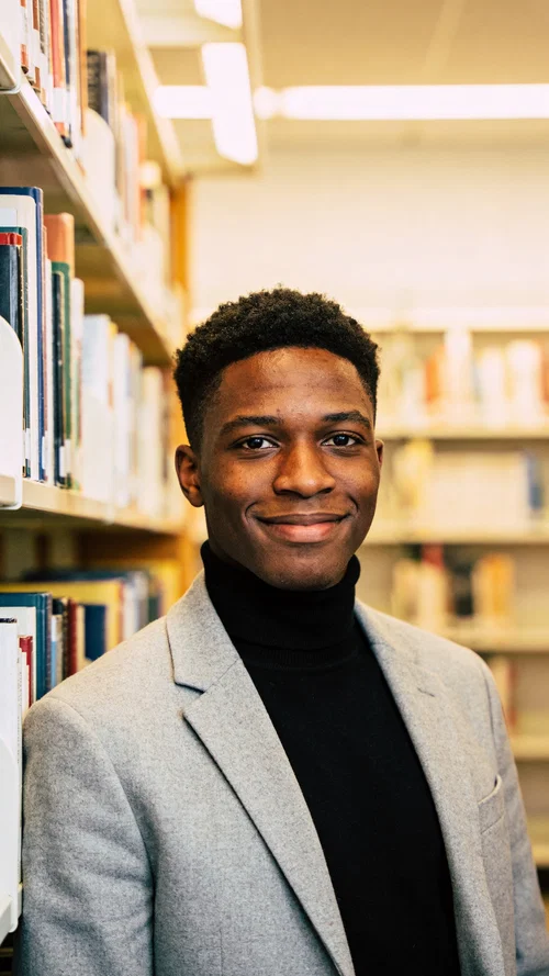 Black man in library setting for sophisticated LinkedIn headshot portrait