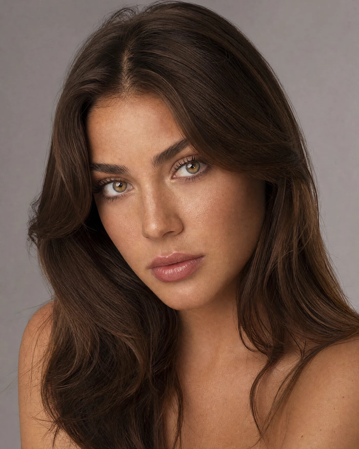 Clean studio headshot of a young adult woman with softbox catchlights and natural skin texture.