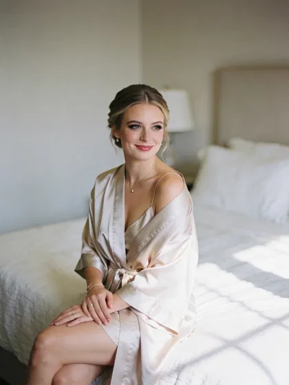 Confident woman in satin robe, soft window-light boudoir portrait
