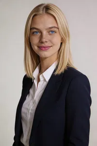Consistent studio headshot, navy blazer, slate-gray background