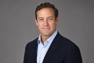 Crisp studio corporate headshot on gray seamless with softbox lighting.