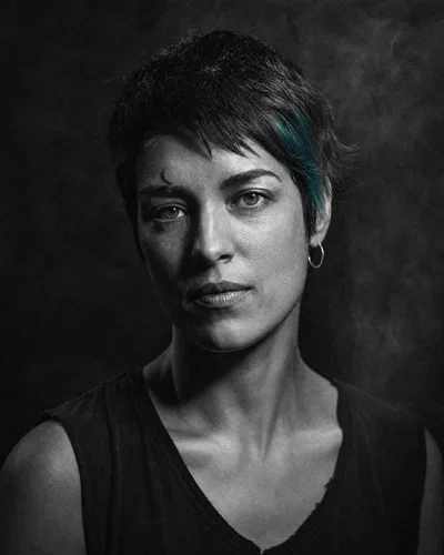 Dramatic black-and-white avatar with hard side light and deep shadows.