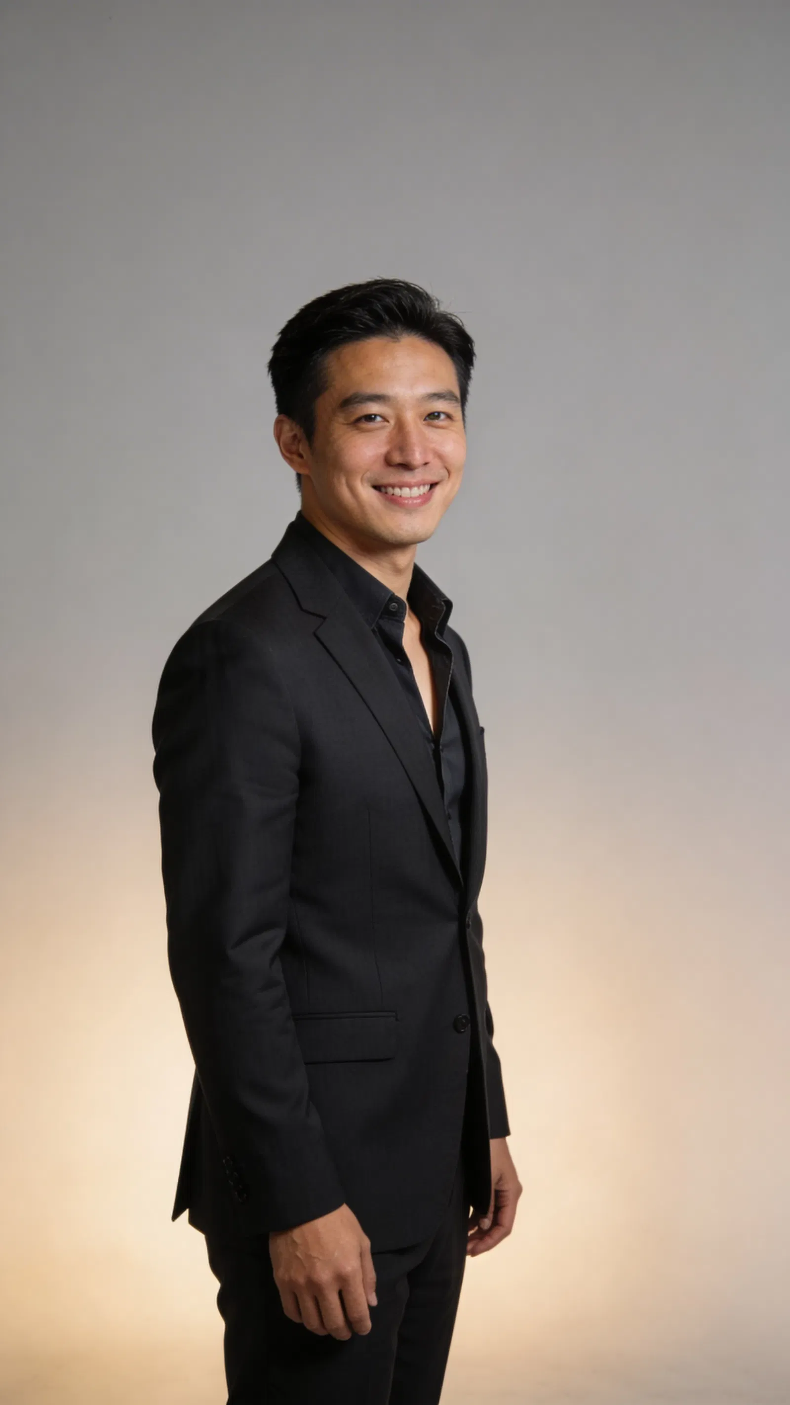 East Asian male attorney half-body studio portrait with modern open-collar style