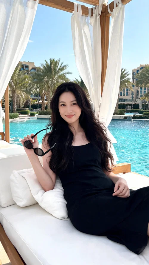 East Asian woman seated poolside at Dubai luxury resort cabana