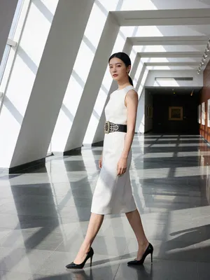 East Asian woman walking in museum hallway editorial fashion photo