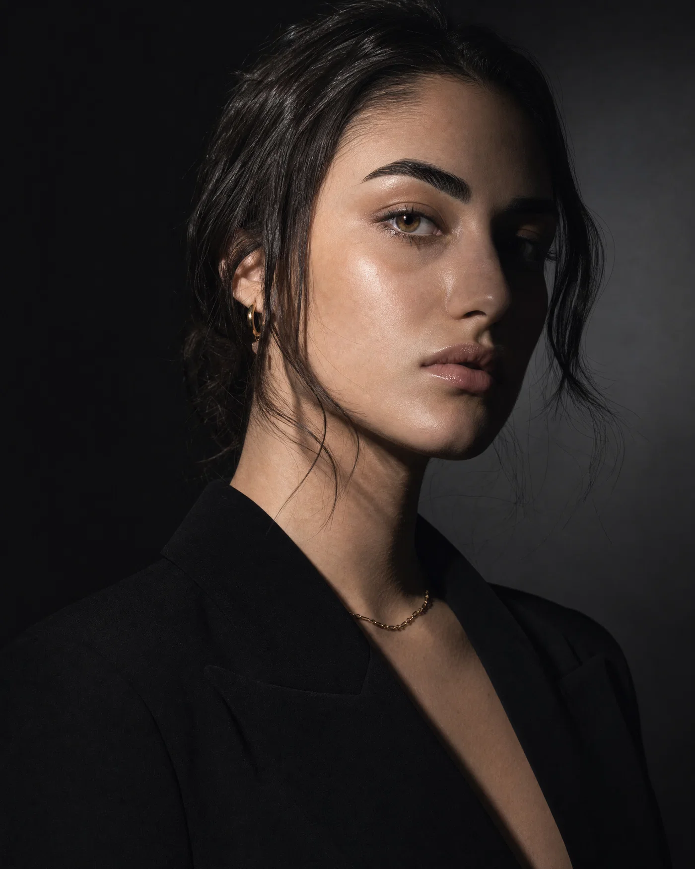High-fashion studio portrait with hard key light, sharp shadows, and crisp editorial contrast.