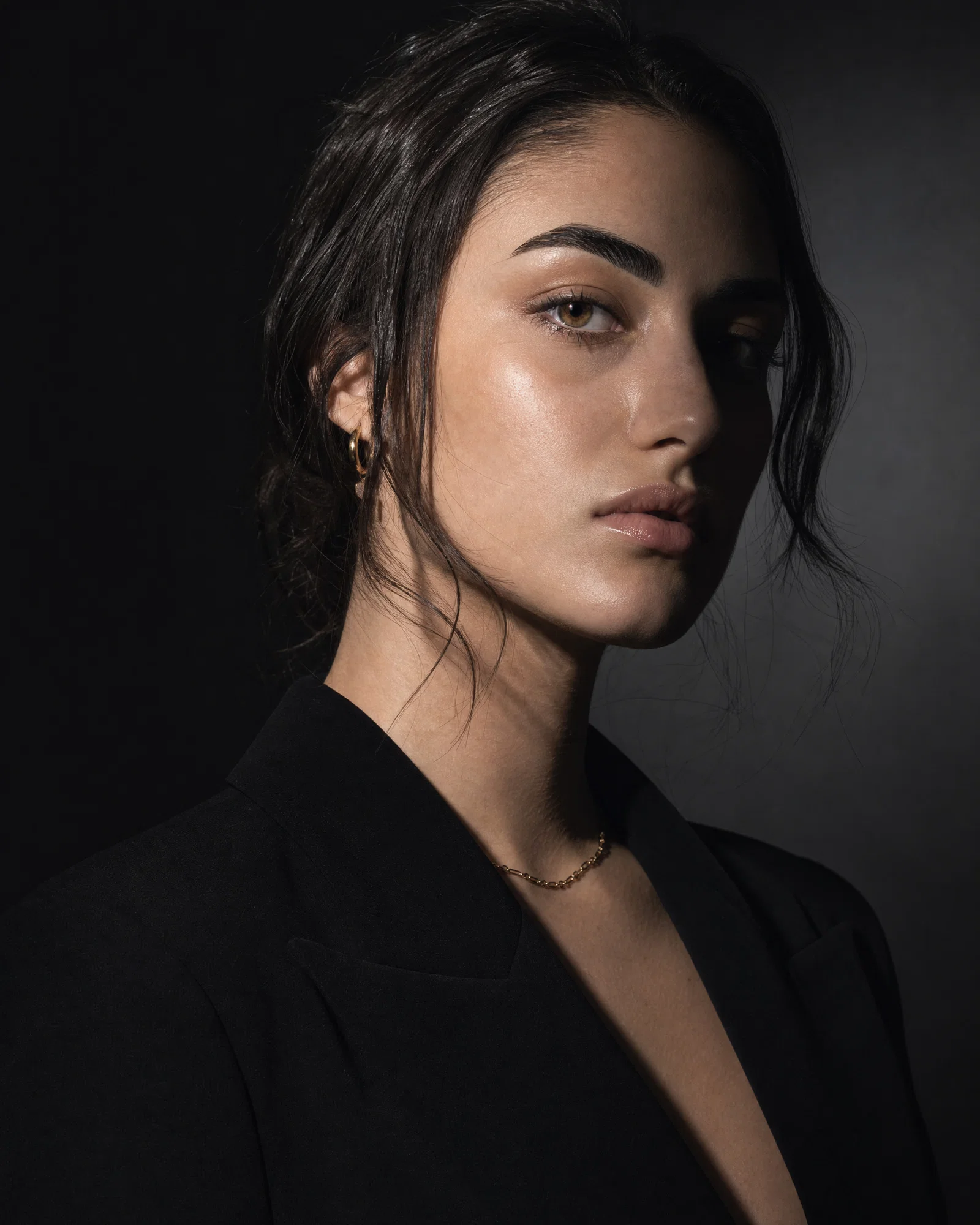 High-fashion studio portrait with hard key light, sharp shadows, and crisp editorial contrast.