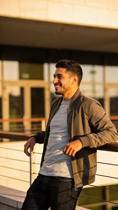Hispanic man leaning on railing outdoors for personal brand photo