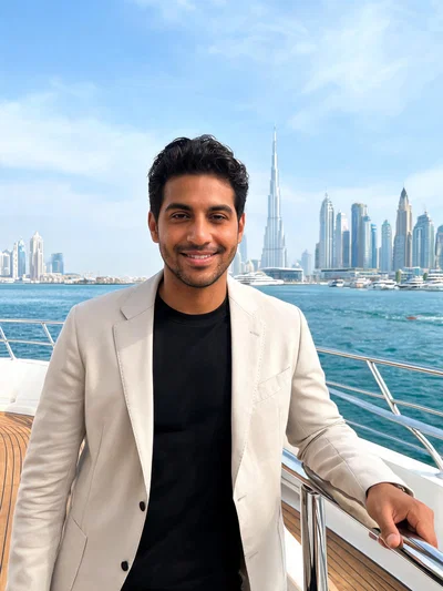 Hispanic man on yacht deck in Dubai Harbor with skyline backdrop