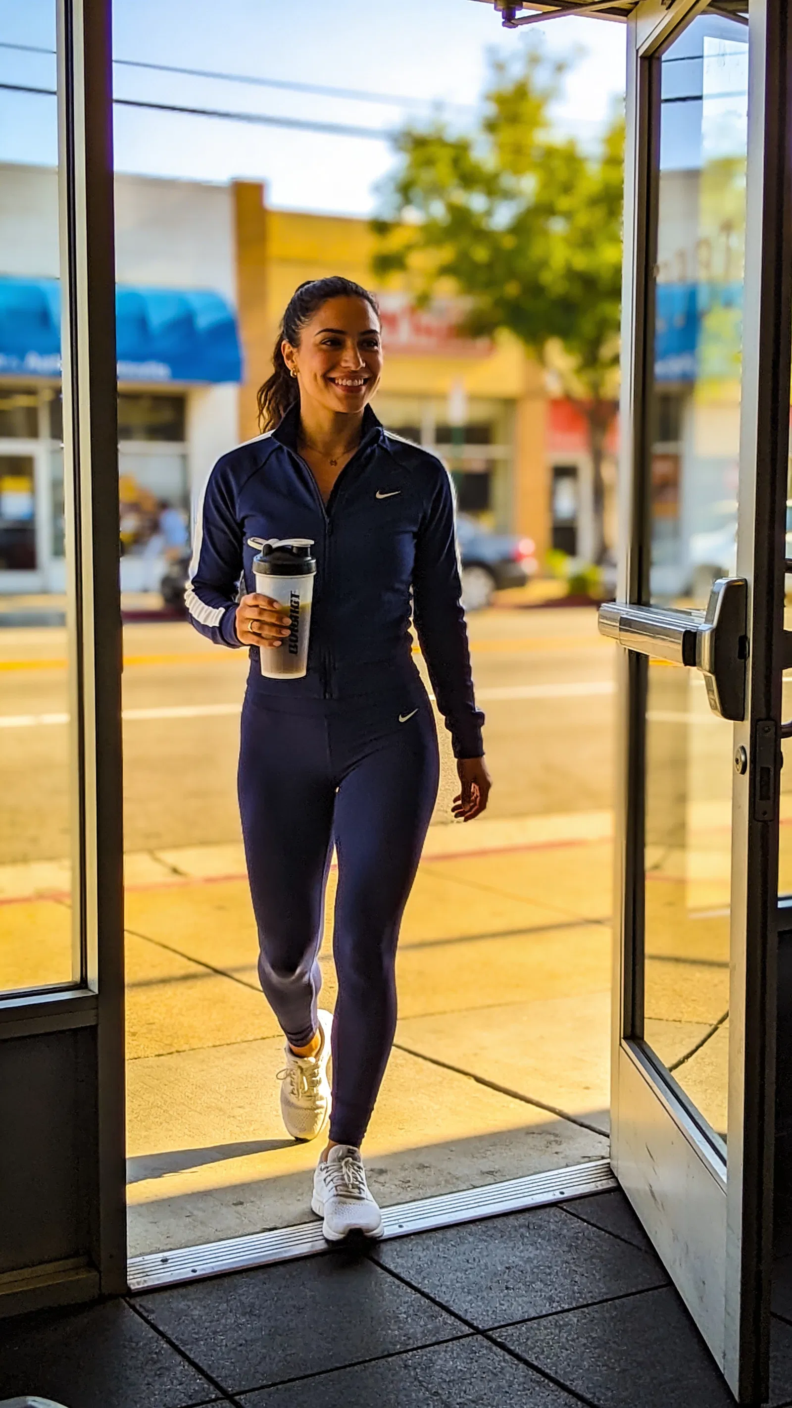 Latina walking outside gym with shaker for fitness branding photos