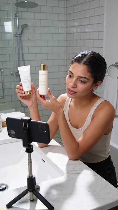 Latina woman filming an honest product comparison Reel at a bright vanity