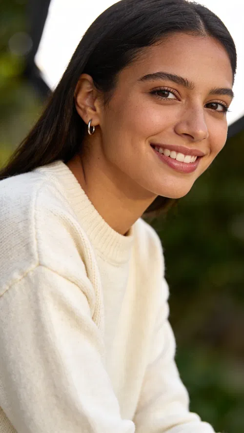 Latina woman outdoor headshot with greenery background and diffused daylight