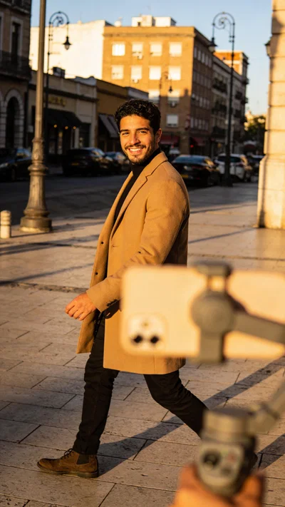 Latino man filming a cinematic walking Reel outdoors with a phone gimbal