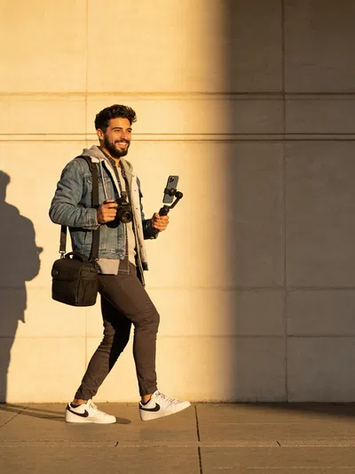 Latino man filming a Reel transition in golden-hour street style