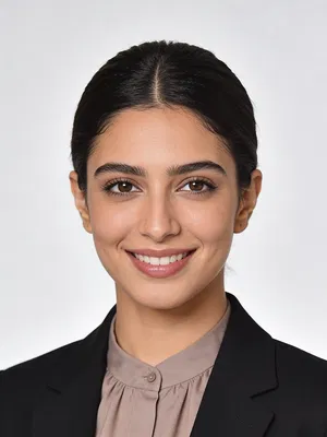 Middle Eastern woman in black blazer with bright studio CV headshot