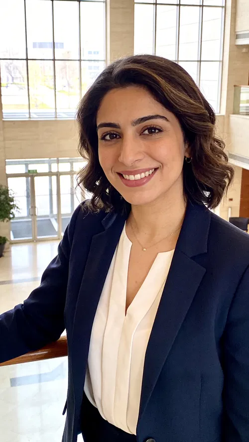 Middle Eastern woman in navy blazer in bright lobby portrait