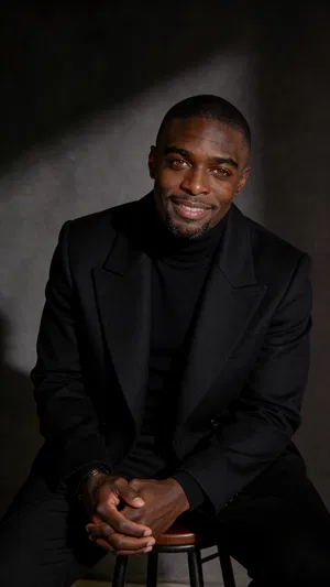 Moody studio seated portrait with sculpted editorial glamour lighting