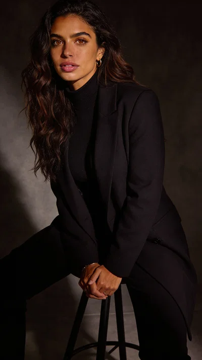 Moody studio seated portrait with sculpted editorial glamour lighting