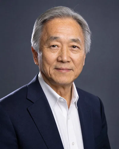 Older East Asian man on slate seamless background with soft key and rim light.