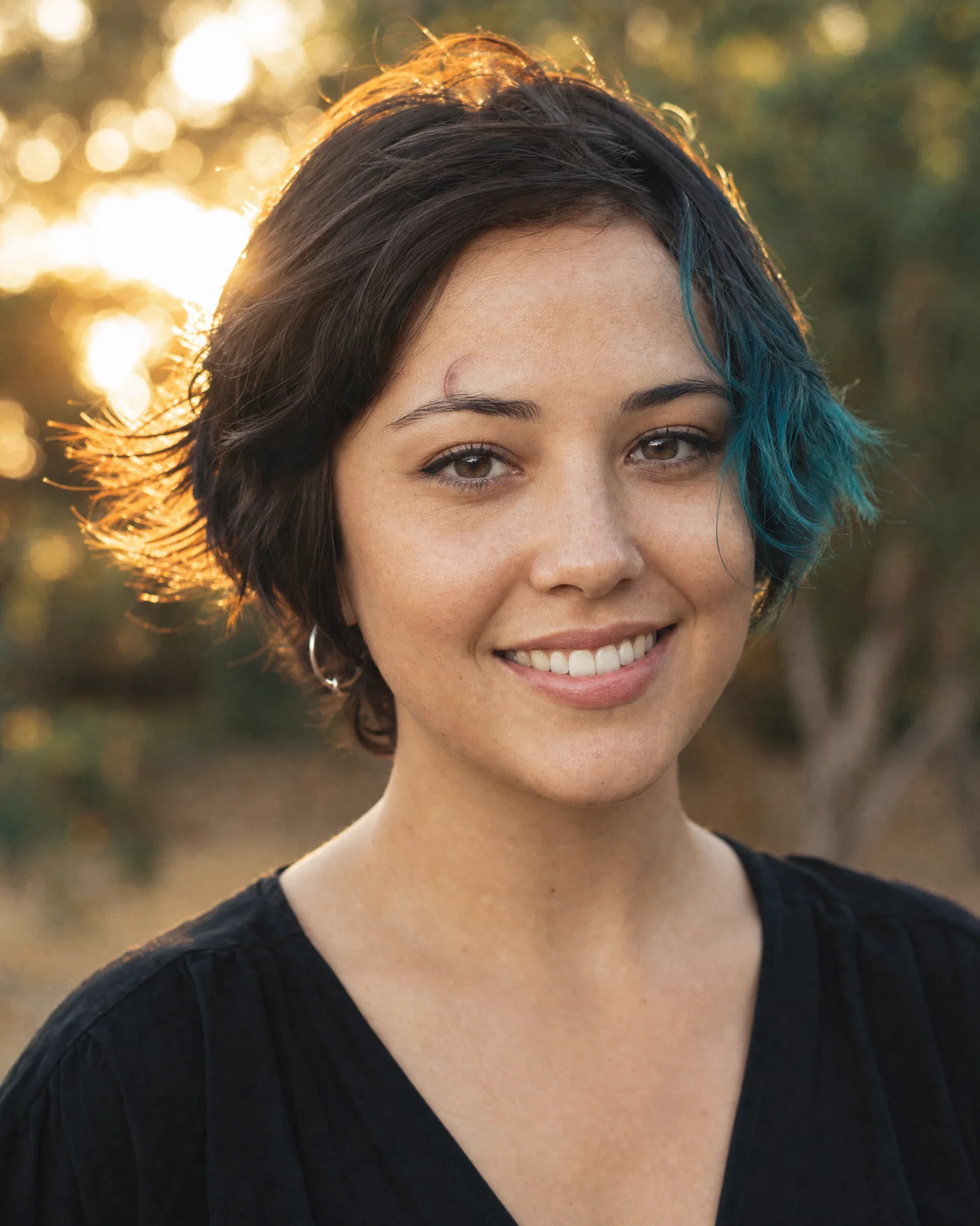 Outdoor golden-hour profile picture with backlight and soft bokeh background.