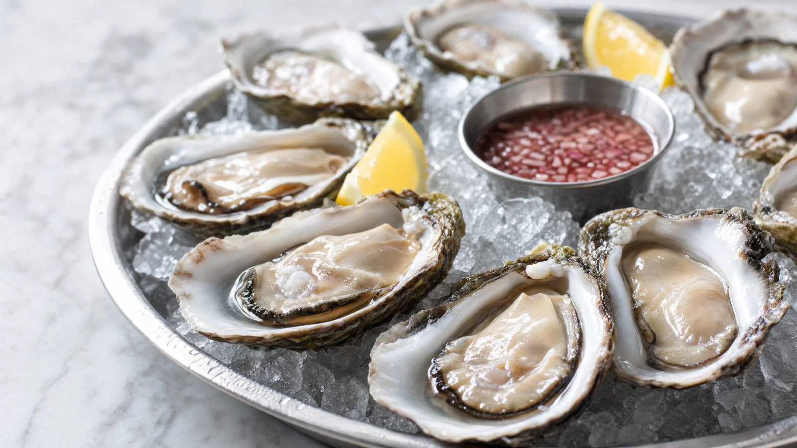 Oysters on ice with lemon on marble, soft side light, crisp realistic texture.