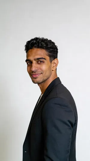 Same character in charcoal suit clean studio profile-style portrait