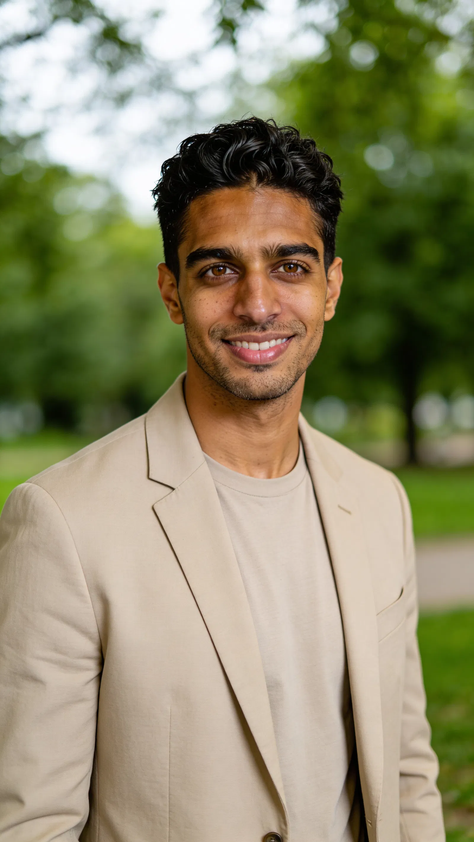 Same character natural outdoor headshot with greenery bokeh and soft light