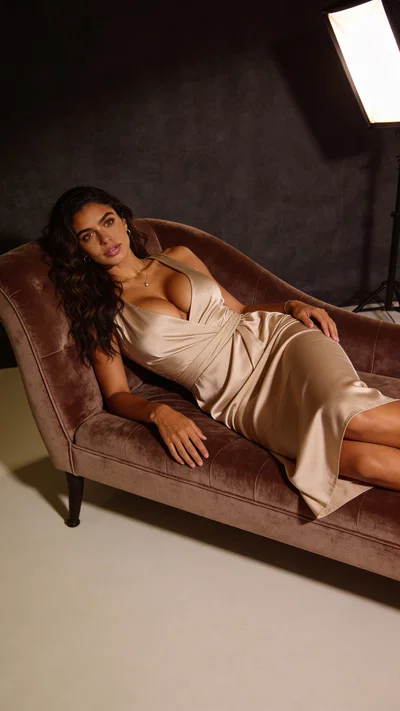 Same character on velvet chaise in moody studio boudoir lighting