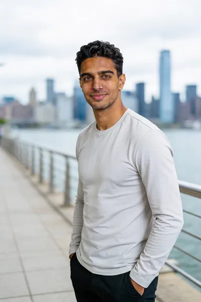 Same man by waterfront, hands in pockets, confident dating profile photo
