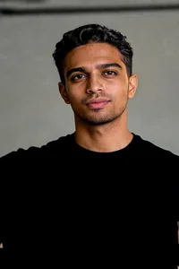 Same man in gym holding dumbbell, fitness looksmaxxing action portrait