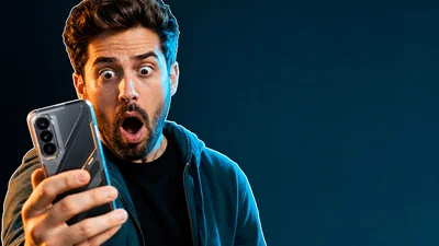 Shocked tech reviewer holding a glowing phone with empty space for headline text