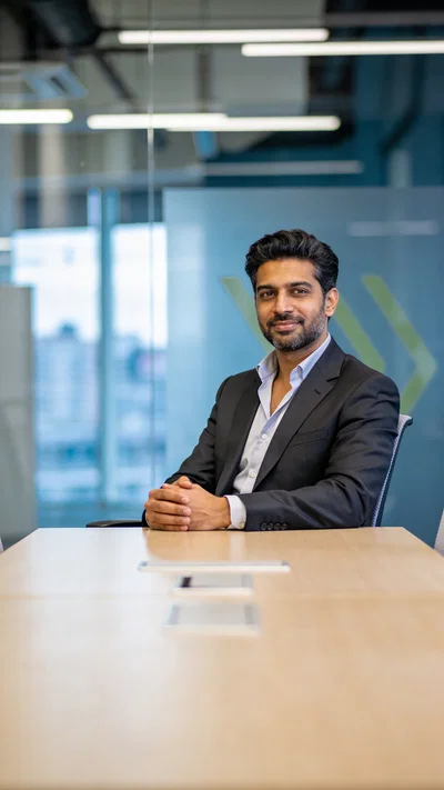South Asian man in boardroom seated portrait for personal branding photography