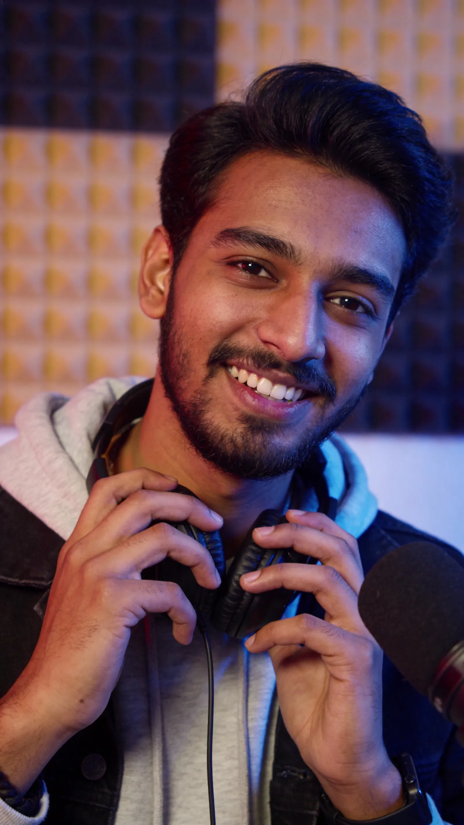 South Asian man in music studio, creative promo portrait for social media