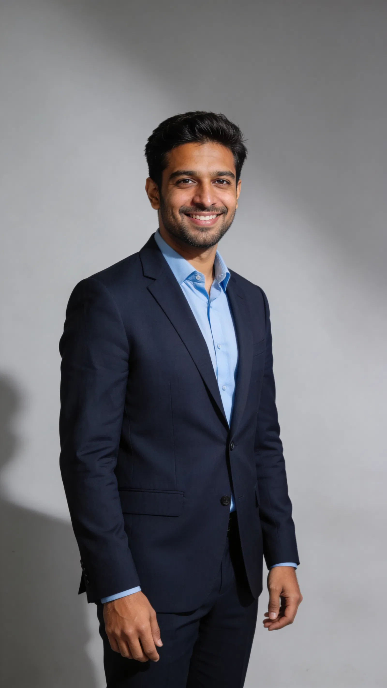South Asian man in navy suit, studio 3/4 portrait for professional AI headshot