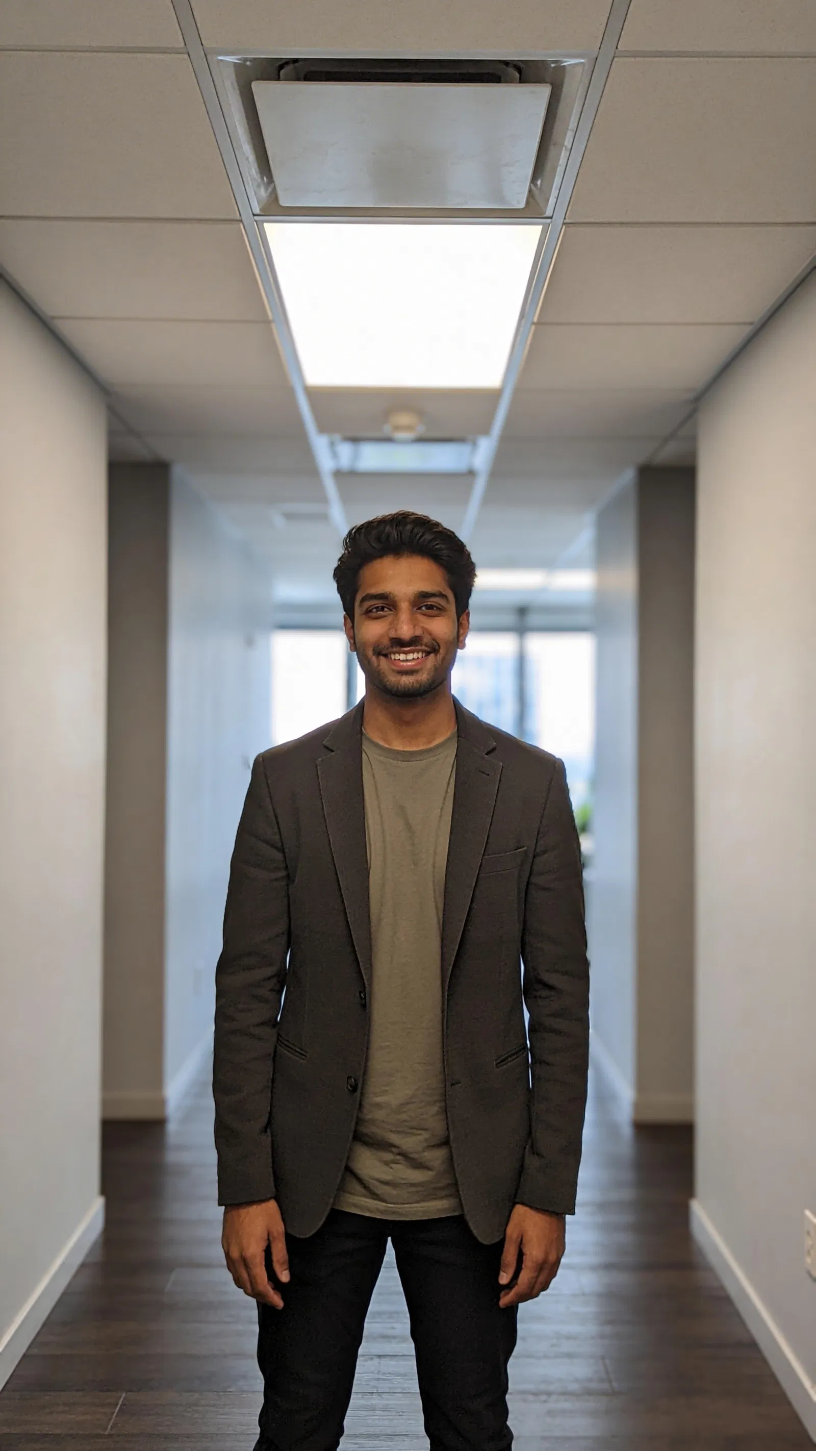 South Asian man in office corridor for credible Instagram content photos