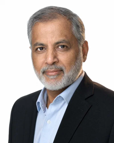 South Asian man on high-key white seamless with rim separation and crisp catchlights.