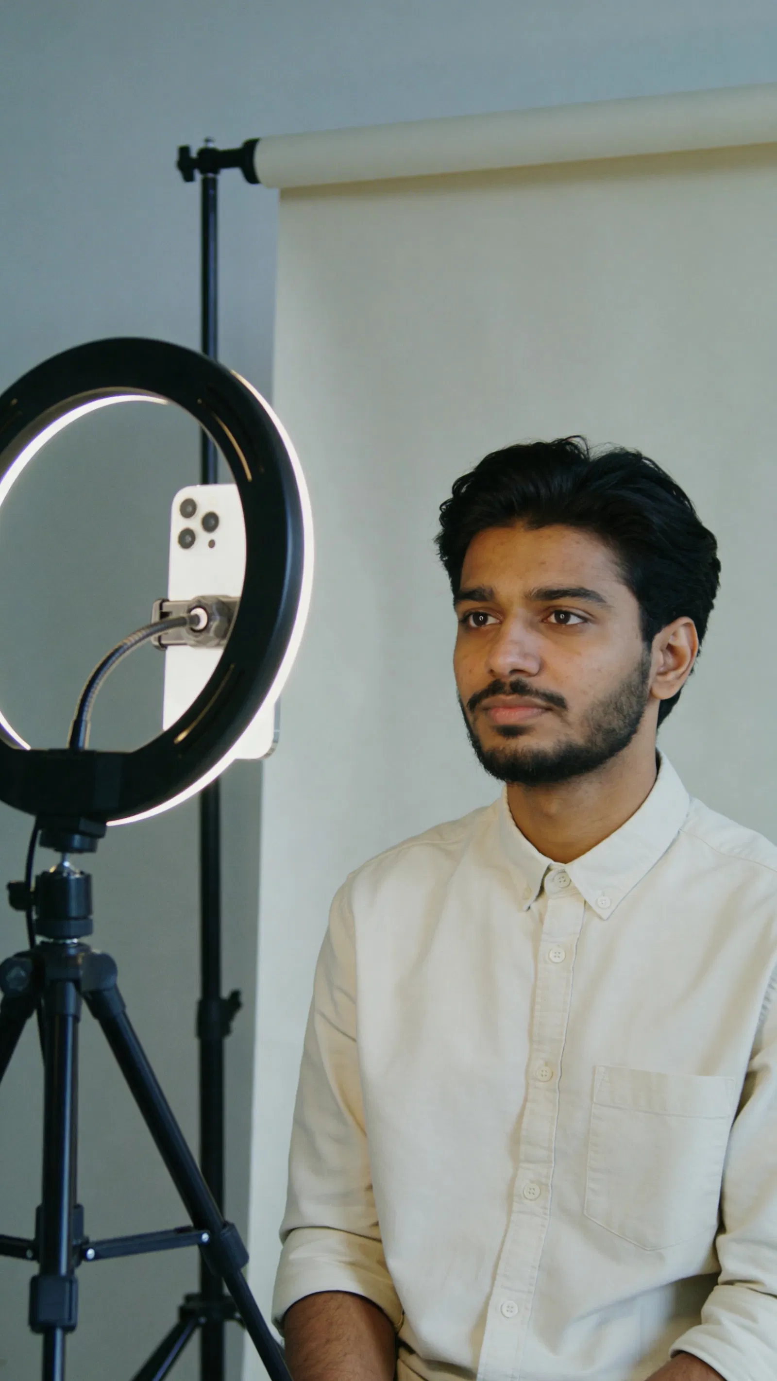 South Asian man shooting consistent headshots for Instagram thumbnails with ring light