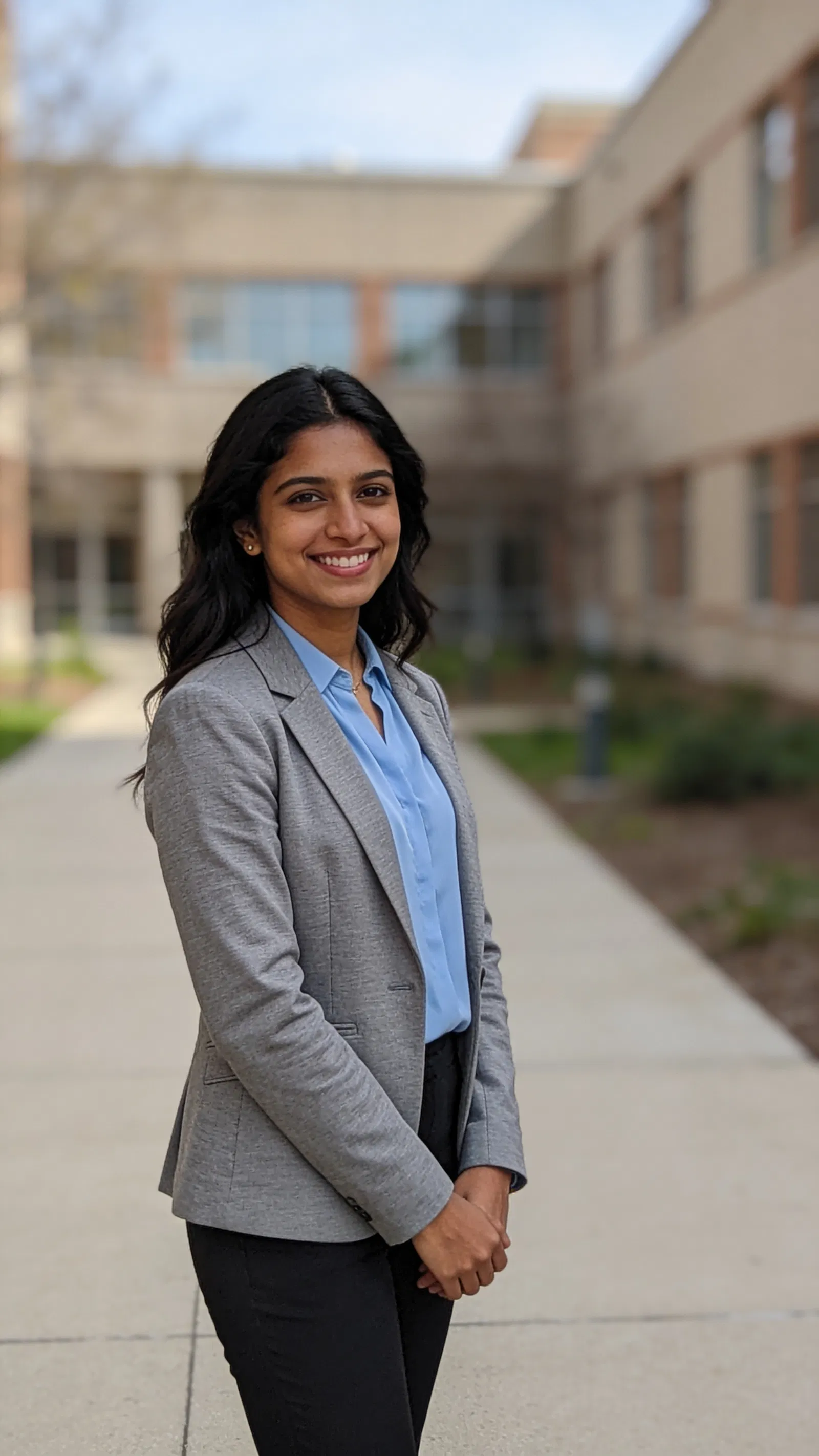 South Asian woman on campus walkway with polished resume photo look