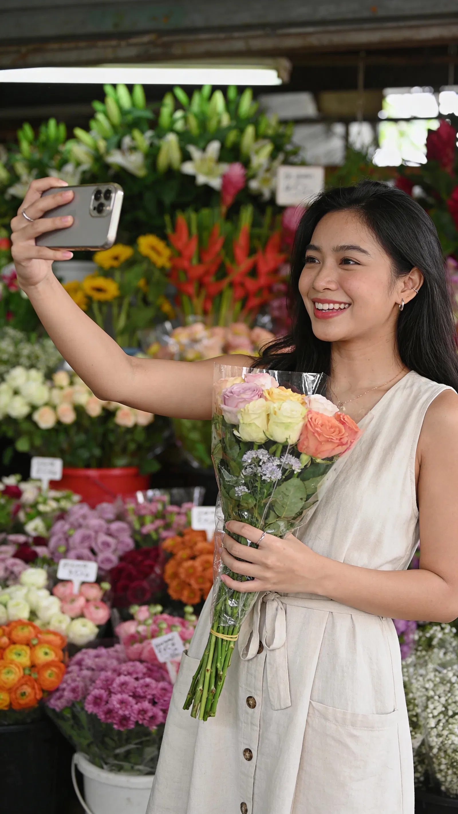Southeast Asian woman filming aesthetic flower-market B-roll for Instagram Stories