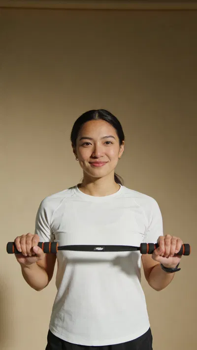 Southeast Asian woman holding resistance band for fitness branding portrait