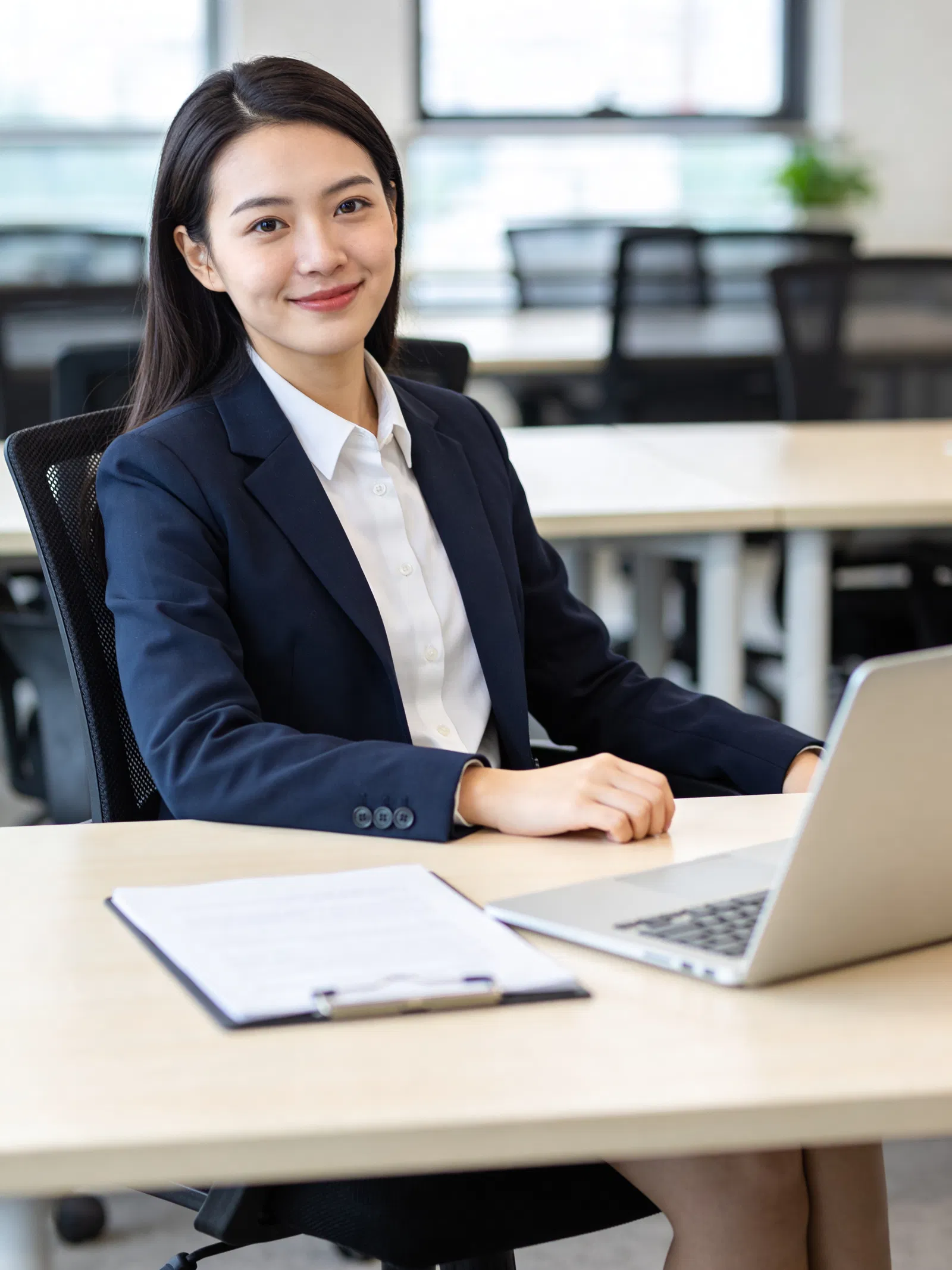 Southeast Asian woman in coworking space with polished chest-up resume portrait