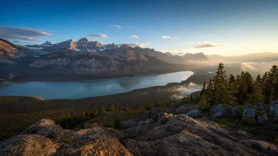Ultra-wide golden-hour mountain lake landscape with realistic haze and crisp detail.