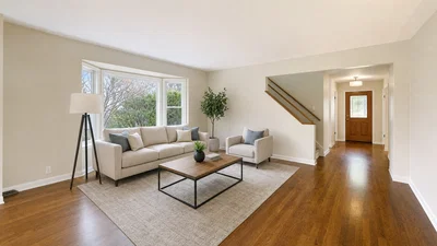 Virtually staged empty living room with correct furniture scale, soft window daylight, and neutral HDR.
