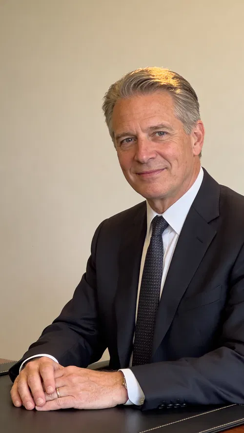 White male senior attorney headshot seated at desk with partner-level authority