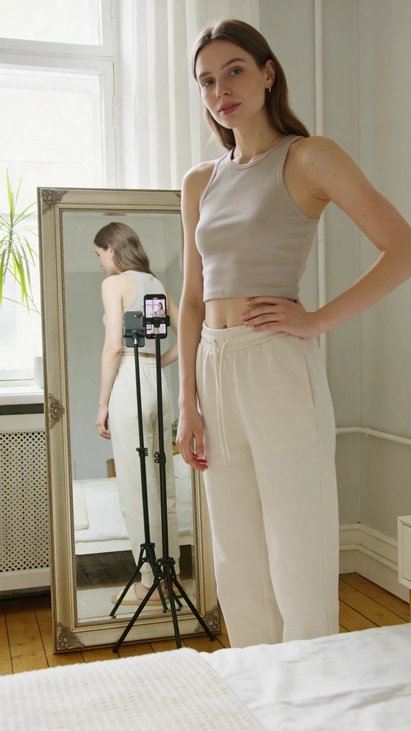 White woman capturing an outfit-of-the-day photo in a bright room