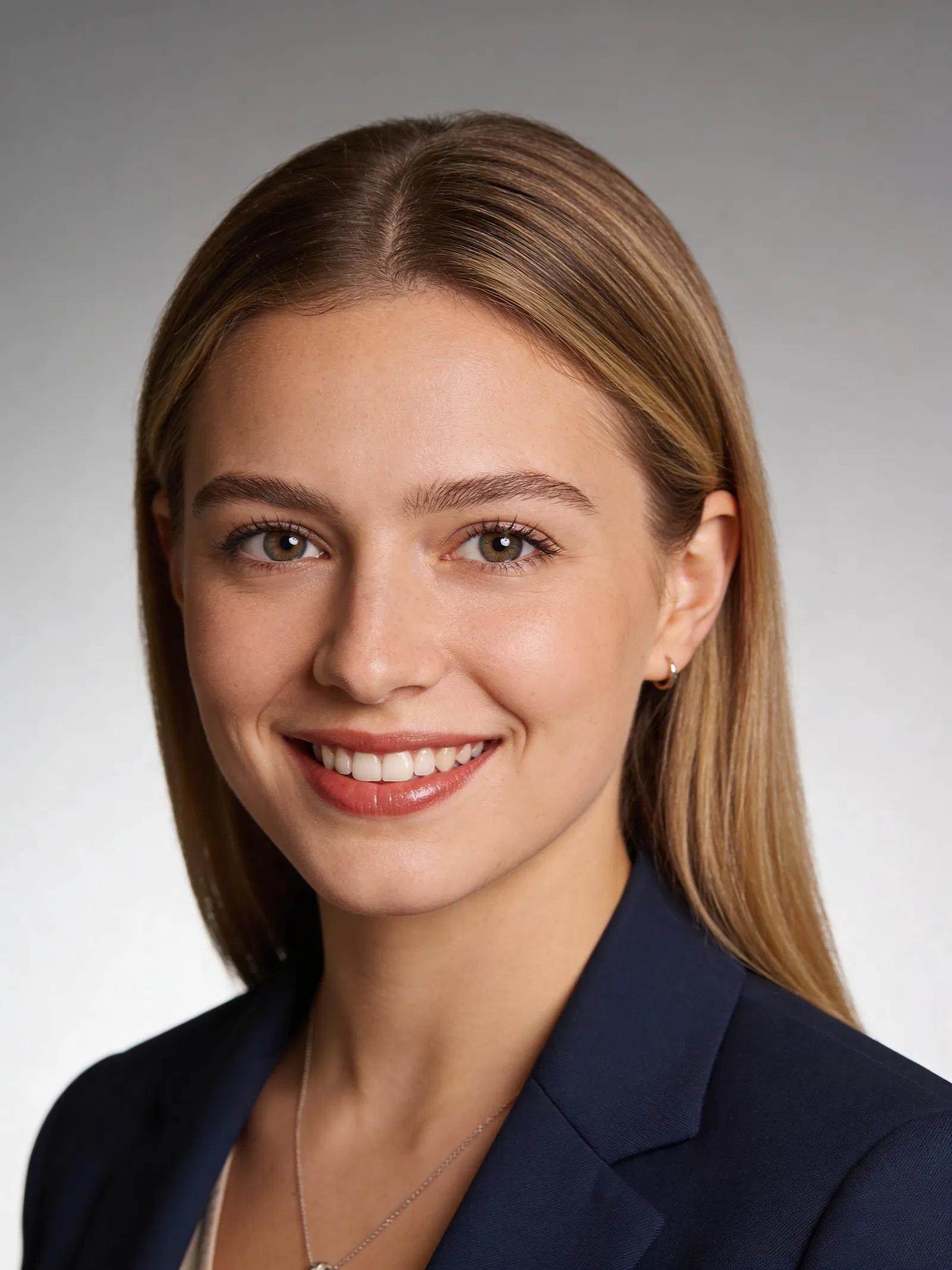White woman professional headshot with confident smile and soft studio lighting