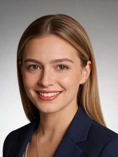 White woman professional headshot with confident smile and soft studio lighting